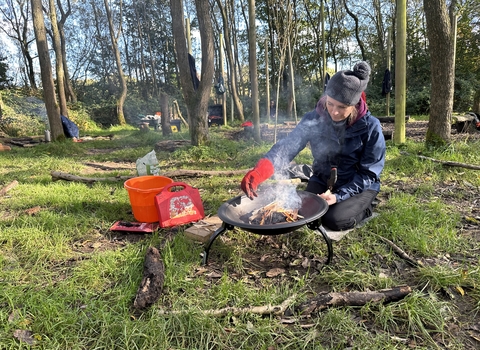Forest School trainee lighting a fire