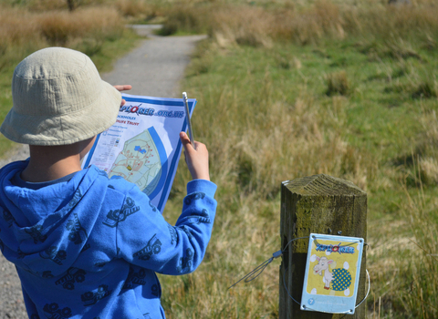 A young boy holding an Xplorer map