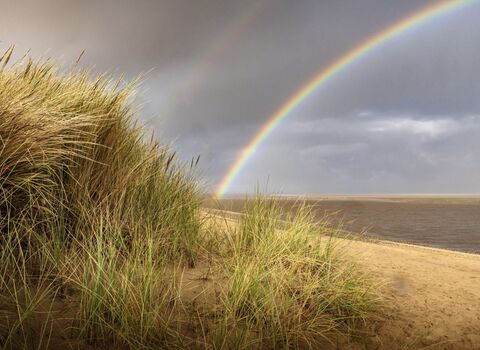 Rainbow over the sea at Fleetwood with the sand dunes in the foreground.